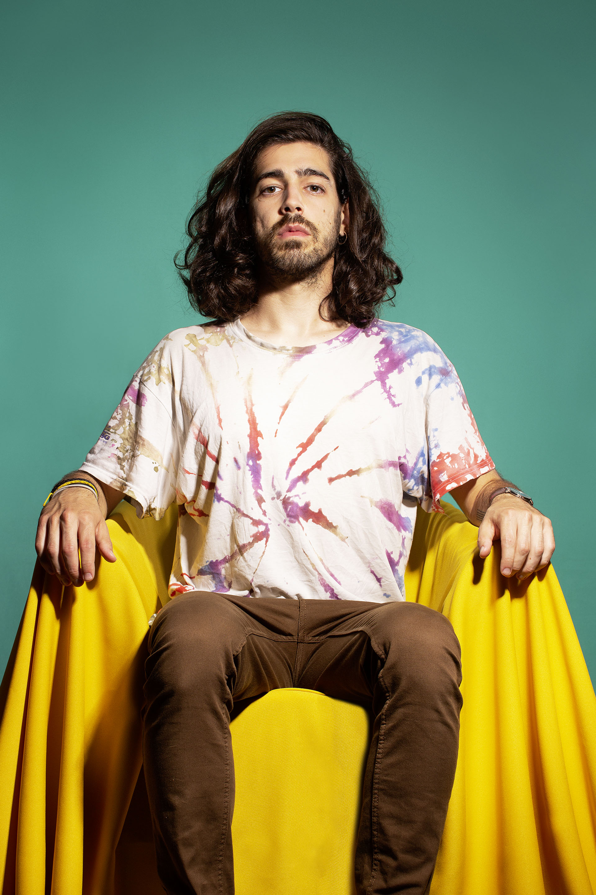 Foto Mann sitzt in Sessel gelb grüner Hintergrund Batikshirt lange Haare stark mächtig autoritär Interview Typografie demokratische Schrift Demokratie Oxlos FH Münster Pumpenhaus Festival der Demokratie DemoX8